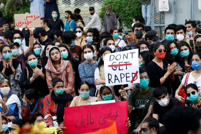 FILE PHOTO: People carry signs to condemn violence against women and girls, during a protest in Karachi,